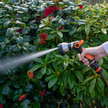Hose water sprayer gun with orange head spraying a wide misty stream