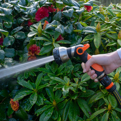 Orange and black hose sprayer gun spraying water with a narrow stream