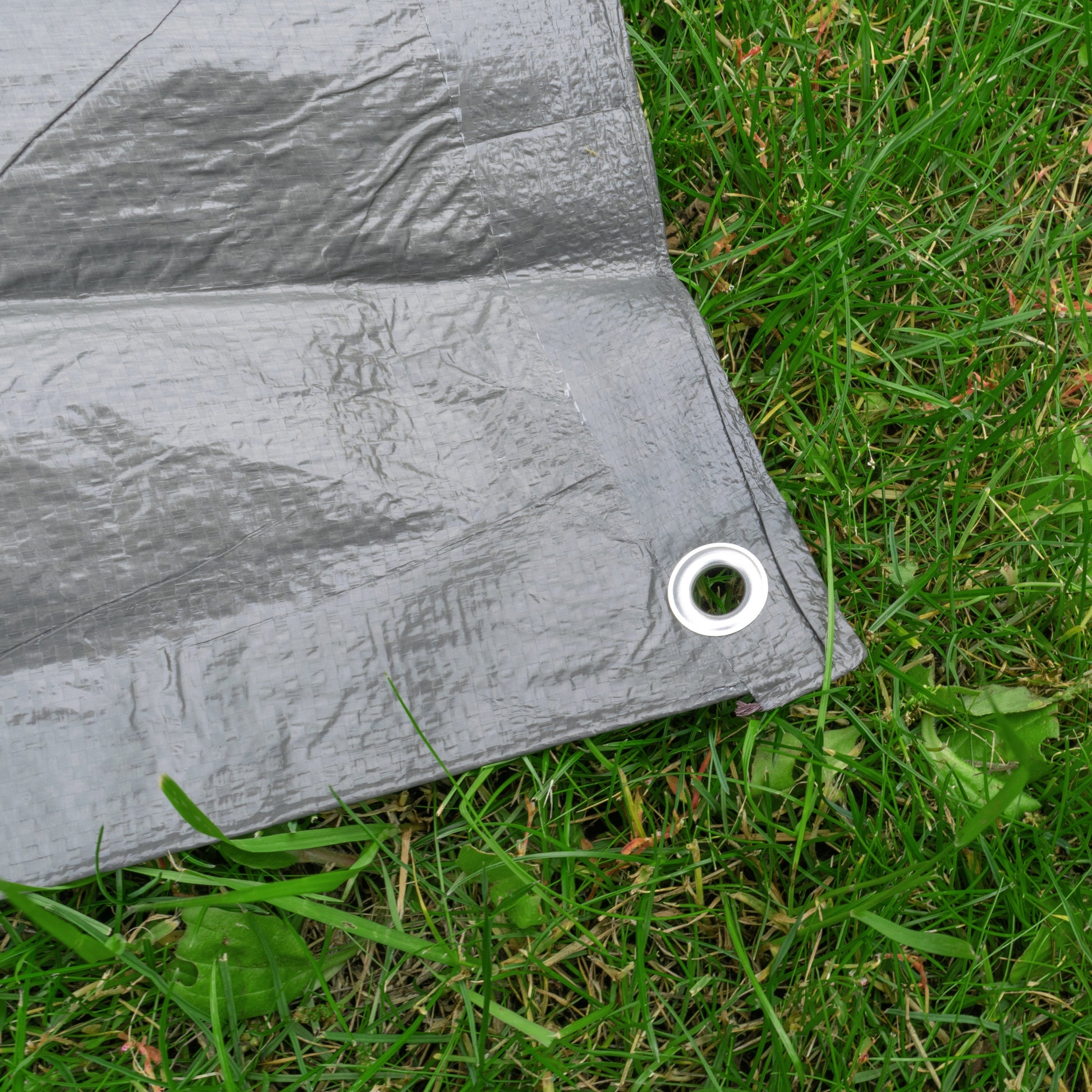 Gray tarpaulin corner with metal ring eyelet on the edge