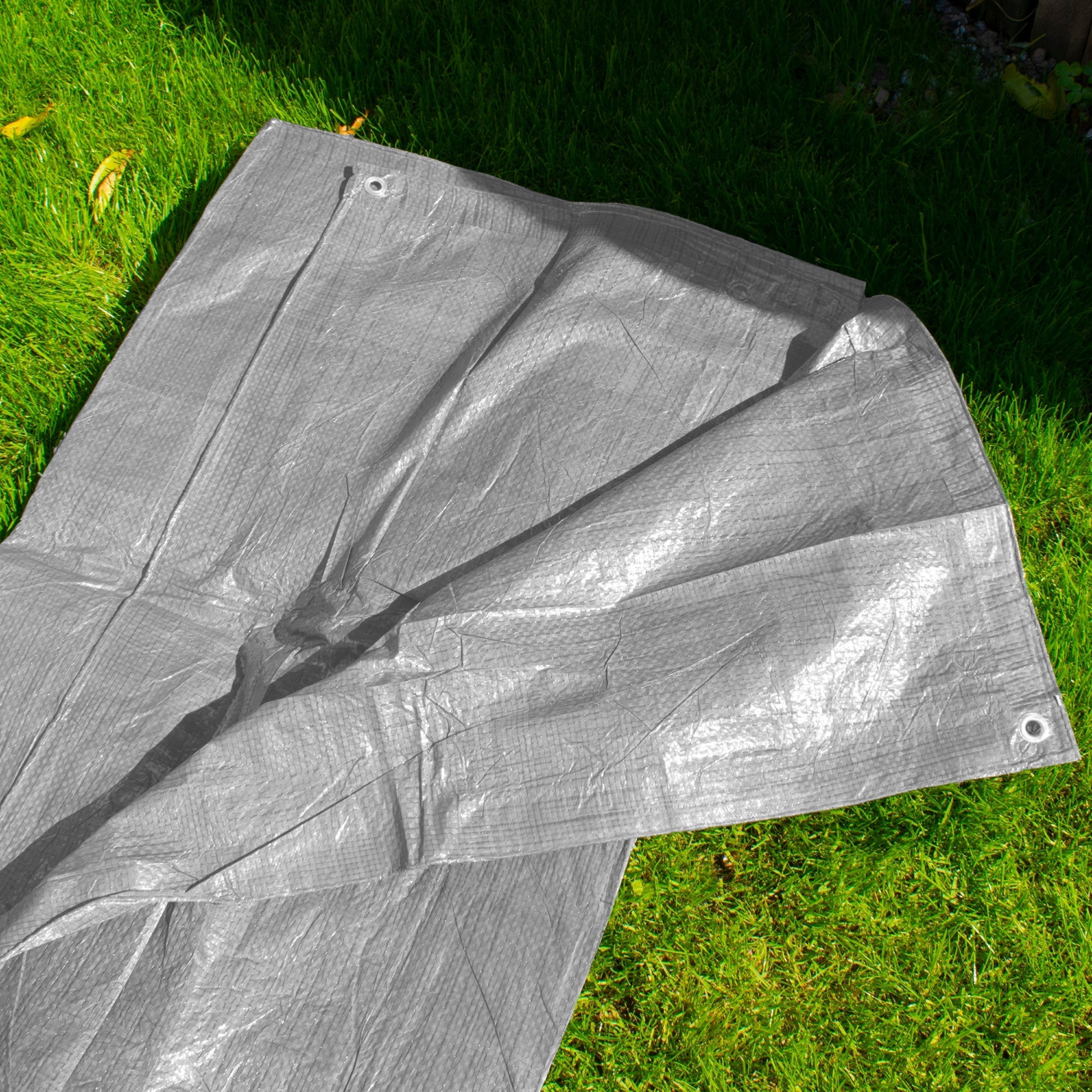 Gray tarpaulin side view with central fold lines and metal eyelet on the edge