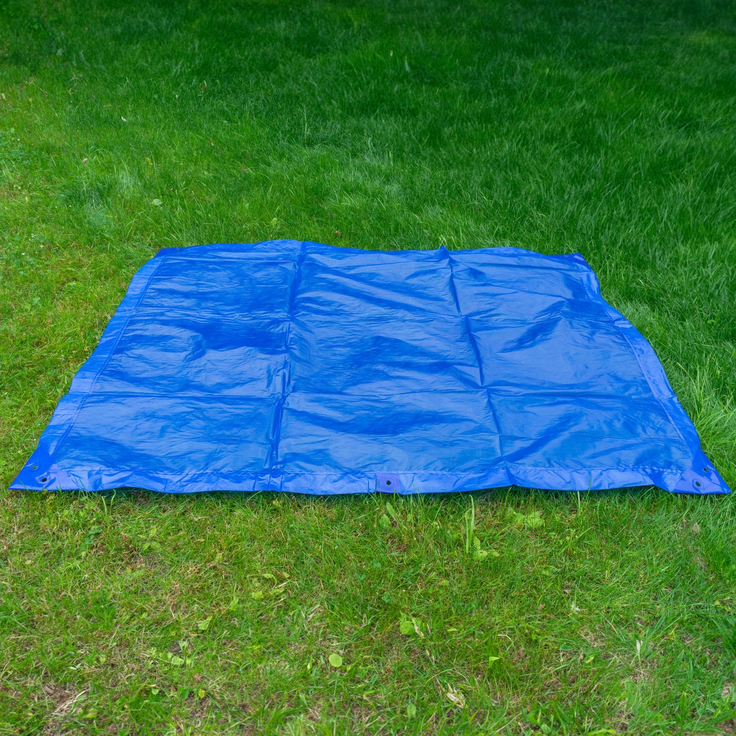Blue tarpaulin sheet 1.5m x 2m spread flat on grass, UV-stabilized texture