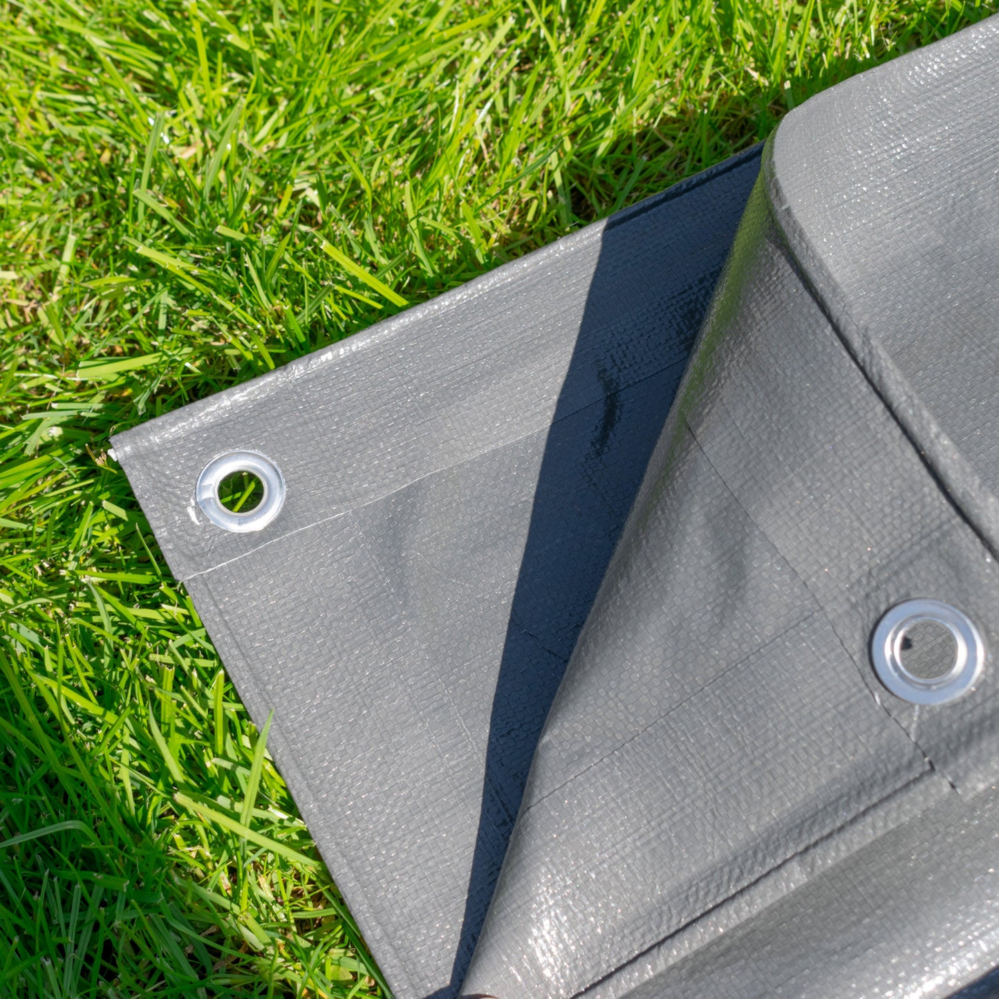 Grey tarpaulin corner with reinforced grommet eyelets on edges