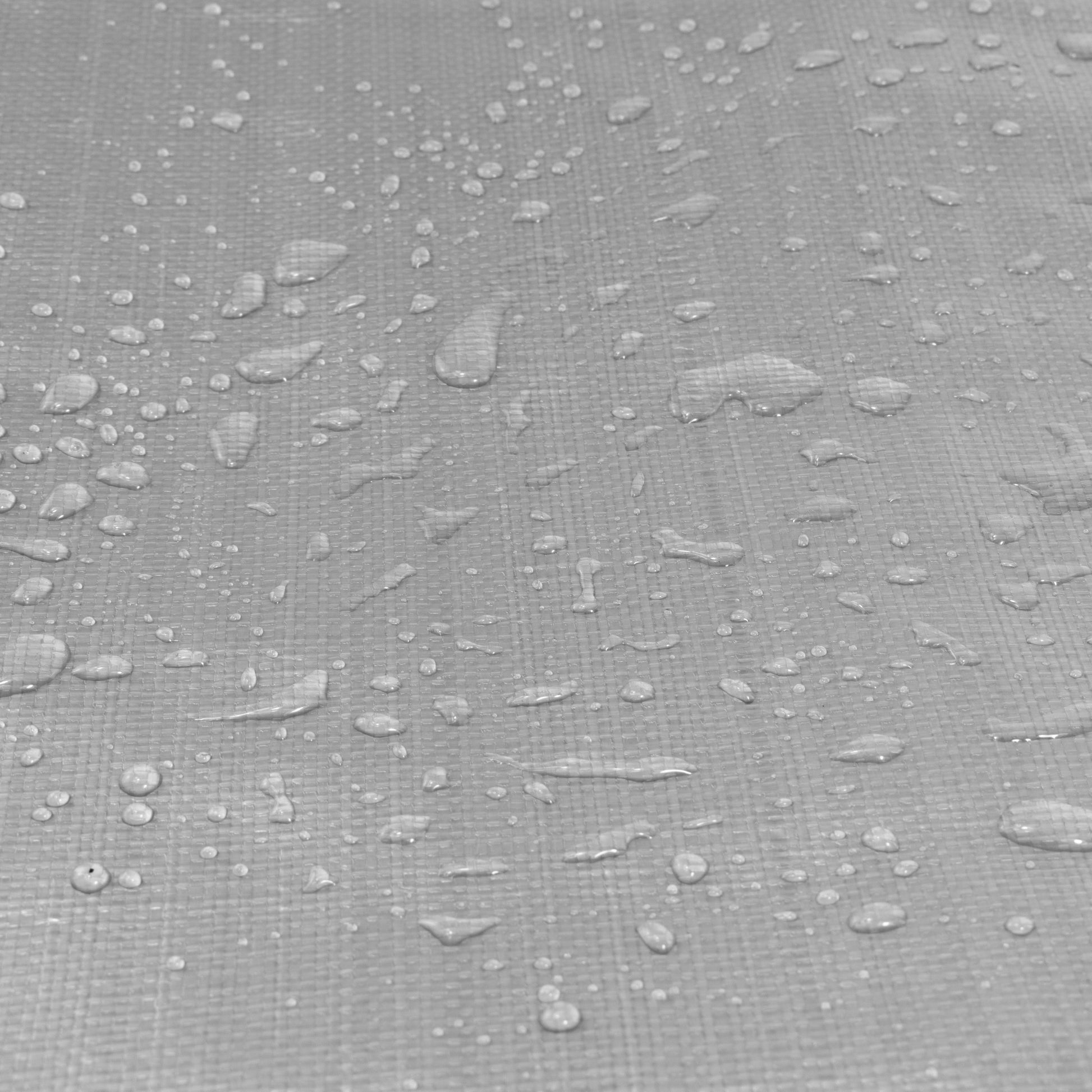 Silver tarpaulin fabric close-up with water droplets on textured surface