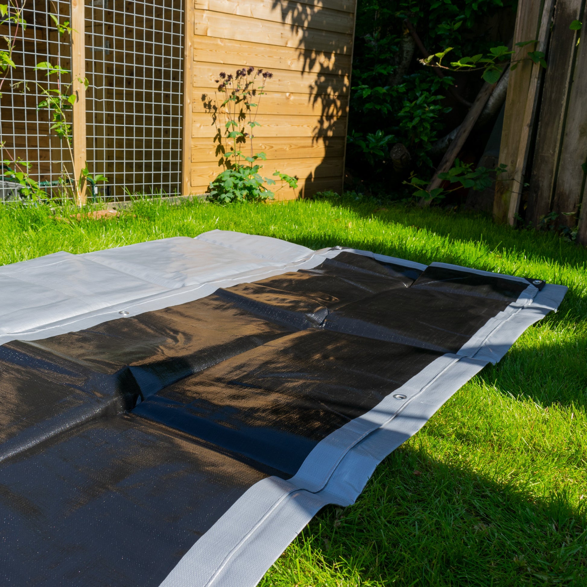Silver tarpaulin sheet laid out flat, 2m x 2m, reinforced edge and seams