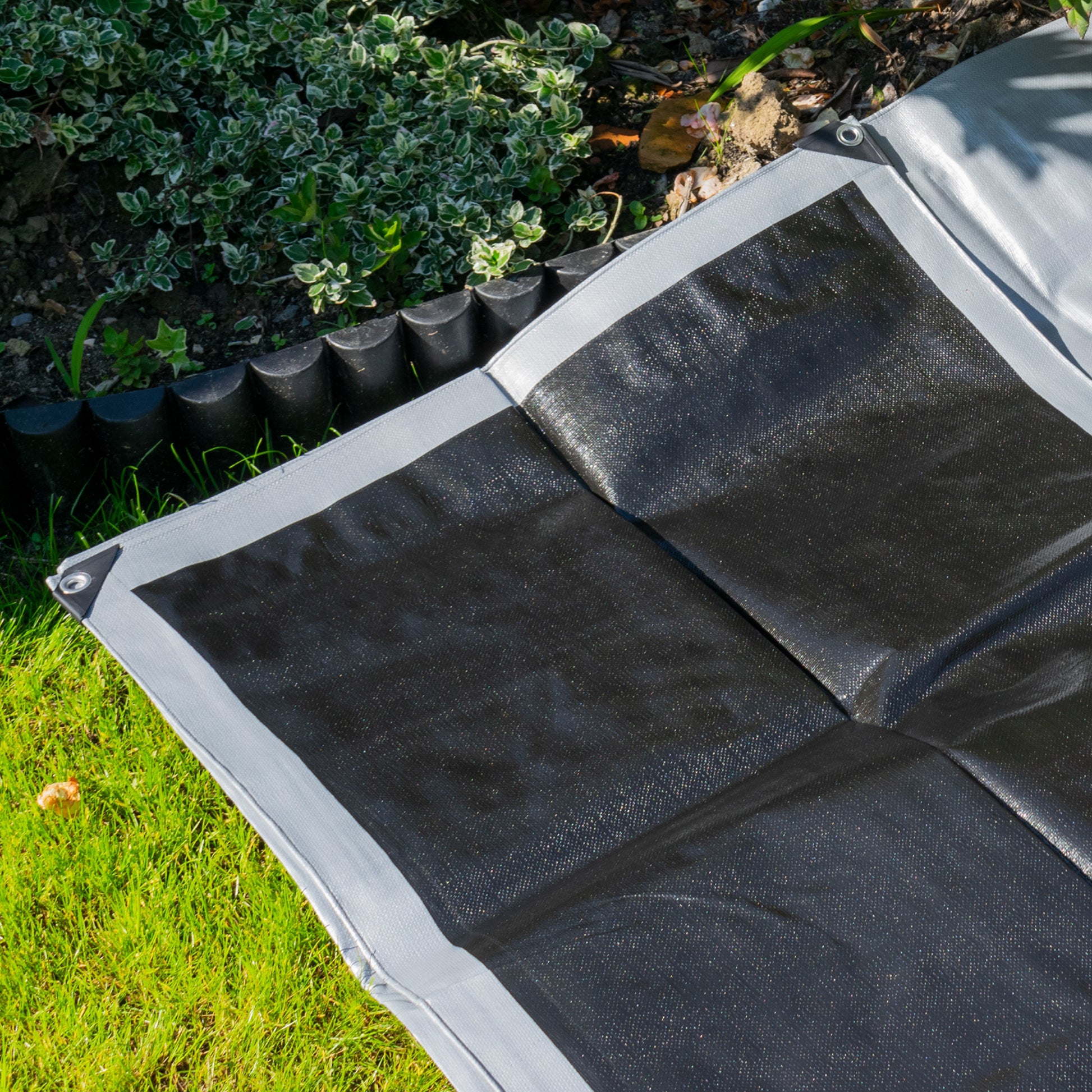 Silver tarpaulin corner with metal grommet and reinforced webbed border