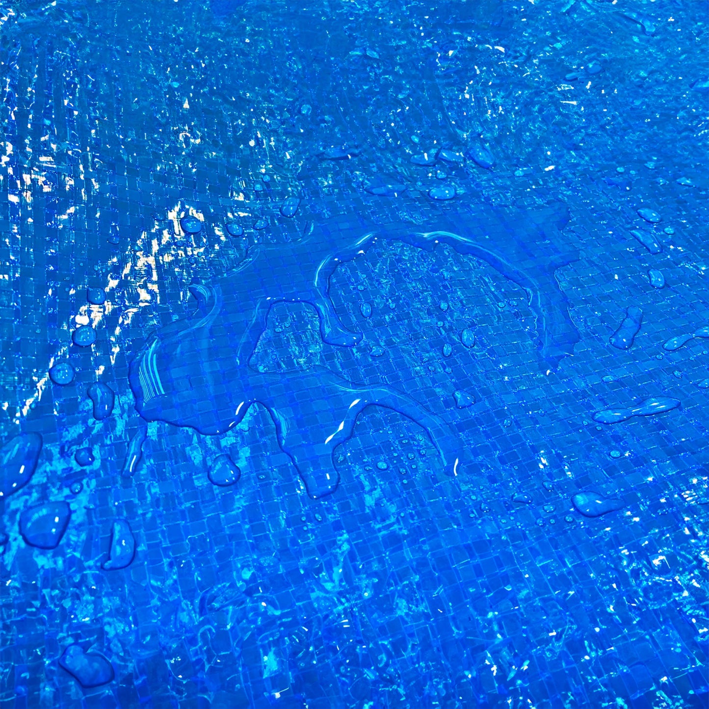 Blue tarpaulin close-up with wet surface droplets on textured weave