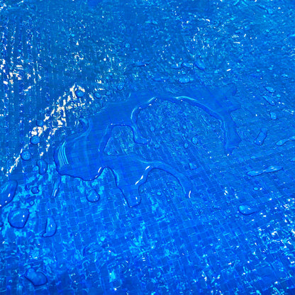 Blue tarpaulin close-up with wet surface droplets on textured weave