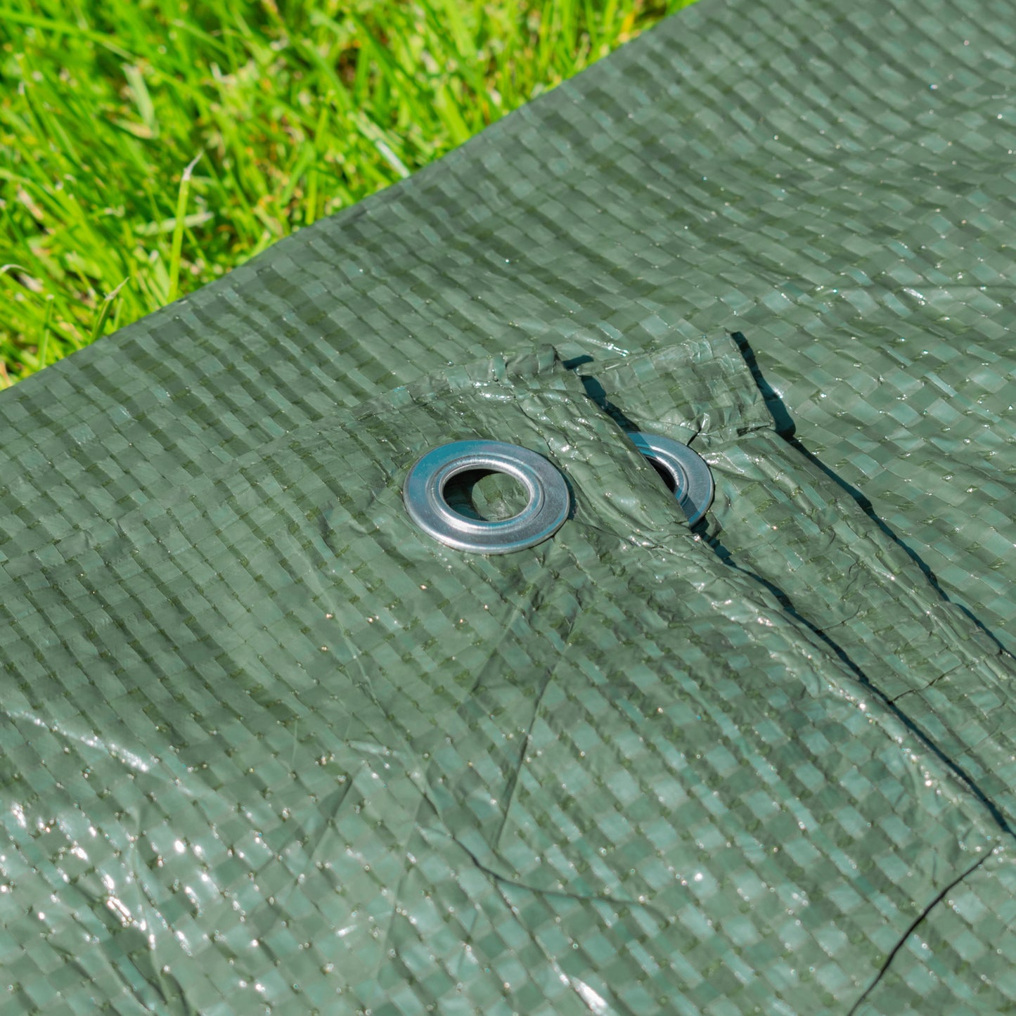 Green tarpaulin eyelet with bungee cord and elastic tie attached