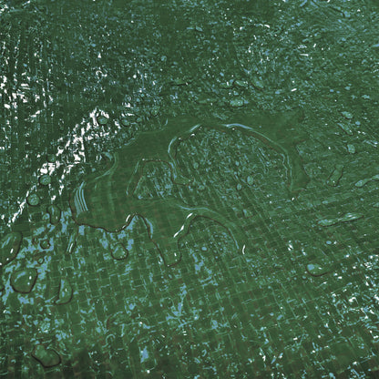 Green tarpaulin waterproof surface with visible droplets on textured weave