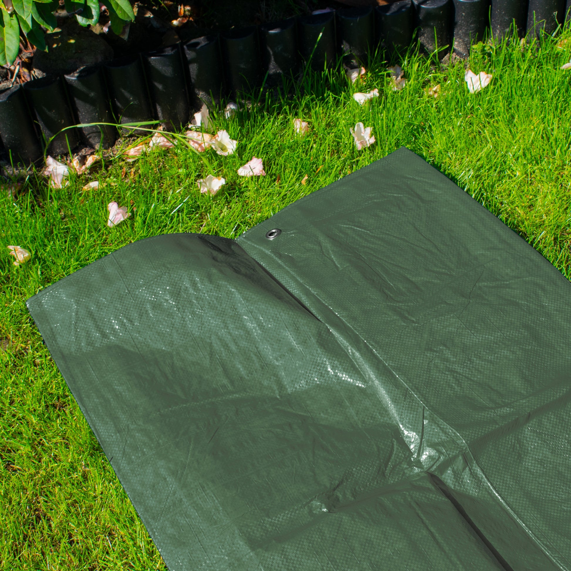 Green tarpaulin sheet with eyelet and stitched edge, laid flat