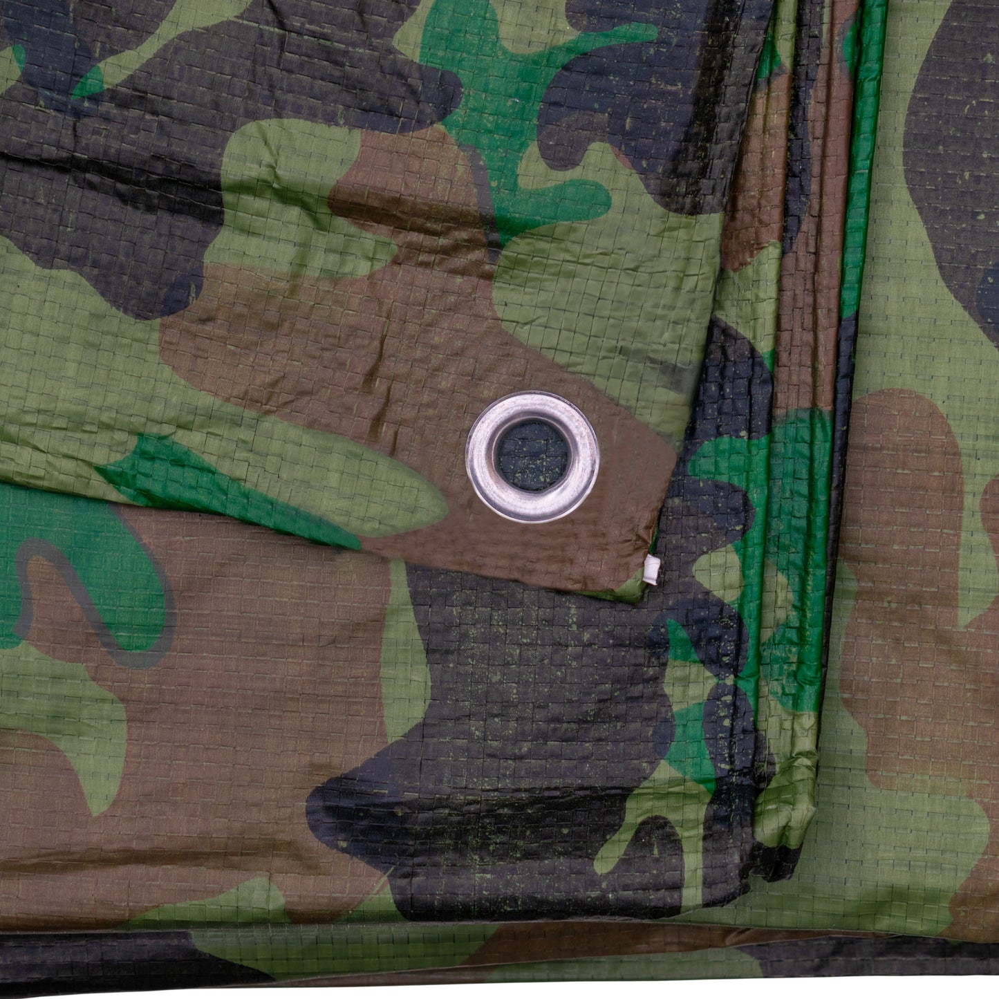 Camouflage tarpaulin close-up fabric texture with metal eyelet and stitching