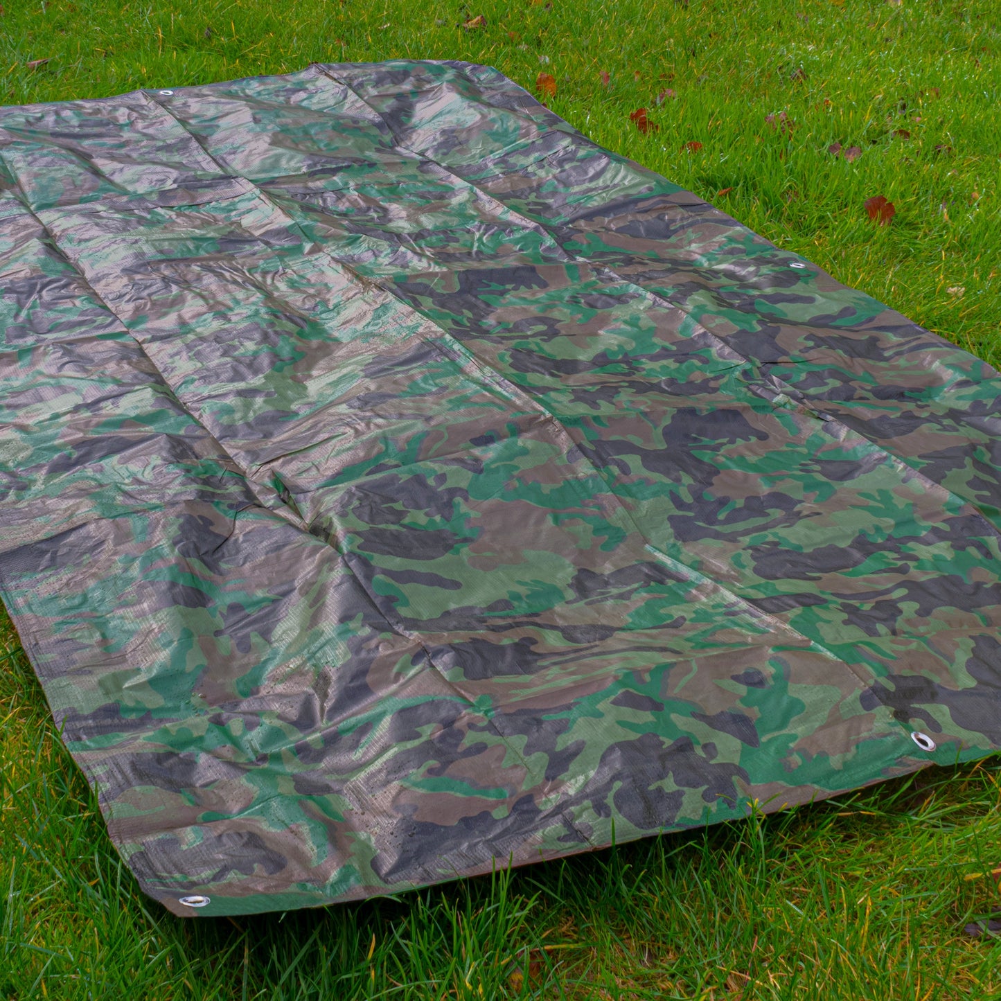Camouflage tarpaulin 3m x 3m laid out on grass