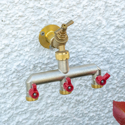 Wall-mounted brass three-way tap splitter with three red shutoff caps and threaded ports