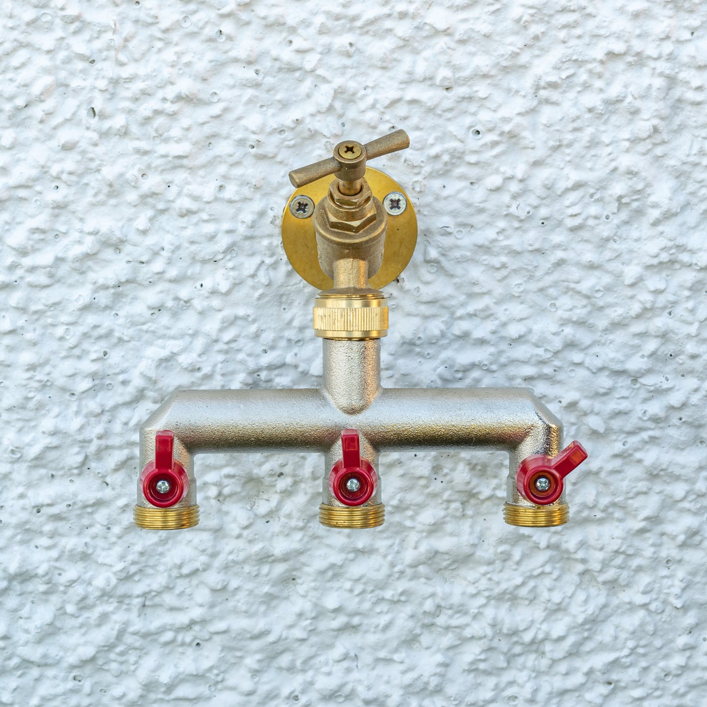 Three-way brass tap splitter with three outlets, red shutoff caps, and 3/4" BSP threads
