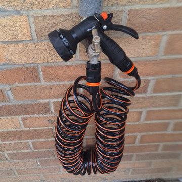Spiral water hose with black and orange coils and dual hose ends for dog shower