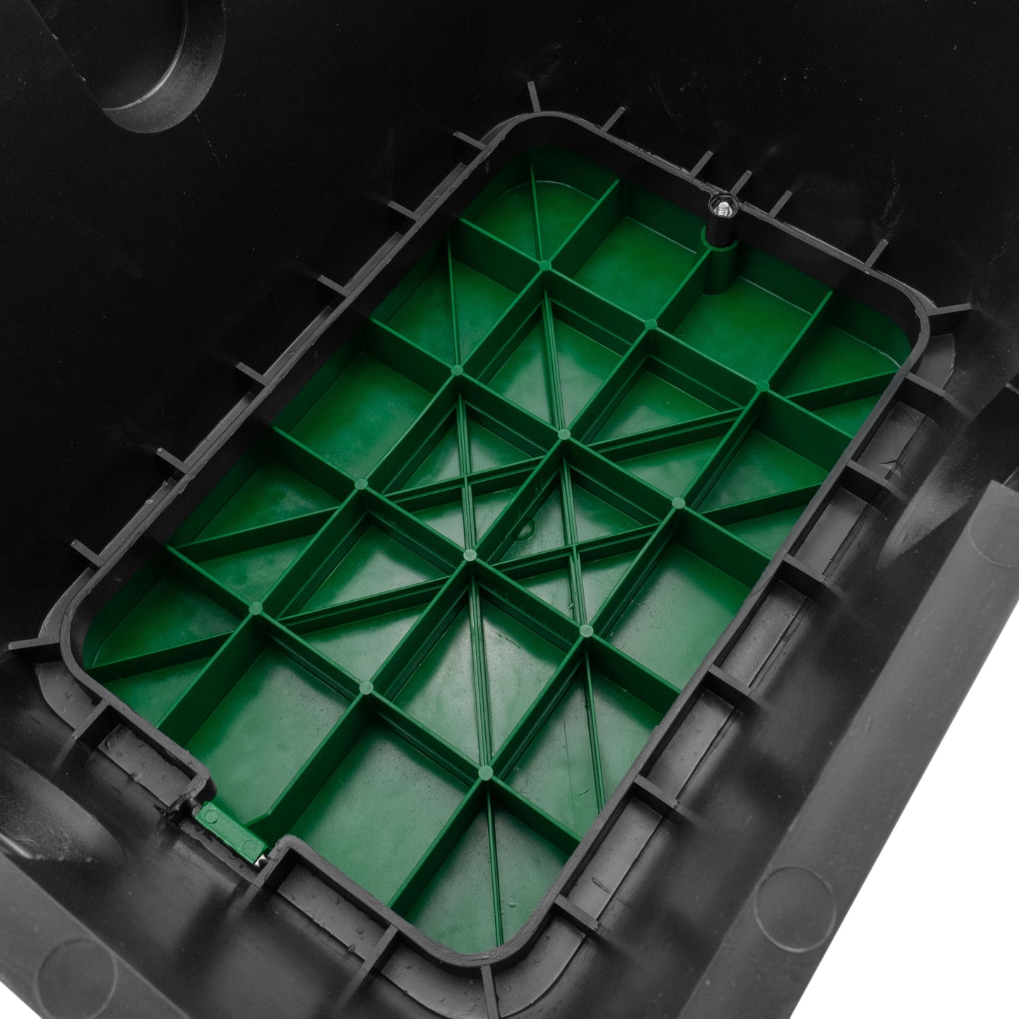 Overhead view of green internal grid with drainage channels inside black valve box