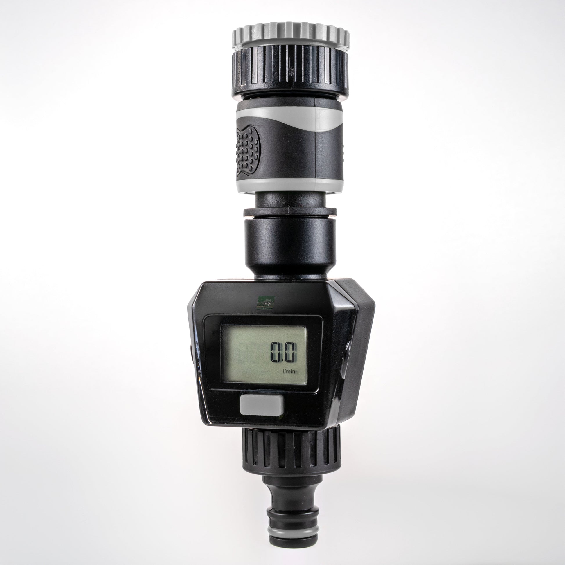 Gray water flow meter with LCD display, silver ribbed top, and inlet/outlet connectors