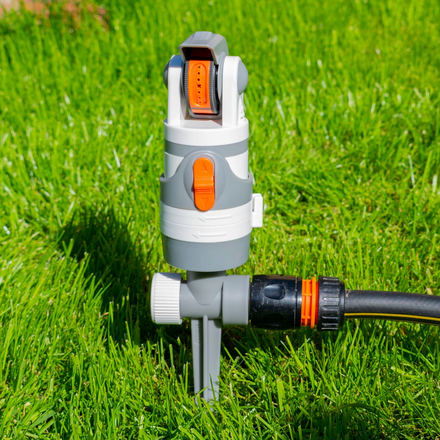 Zahnradsprenger für Gartenbewässerung mit Erdspieß, weiß-grauem Gehäuse und orange Details