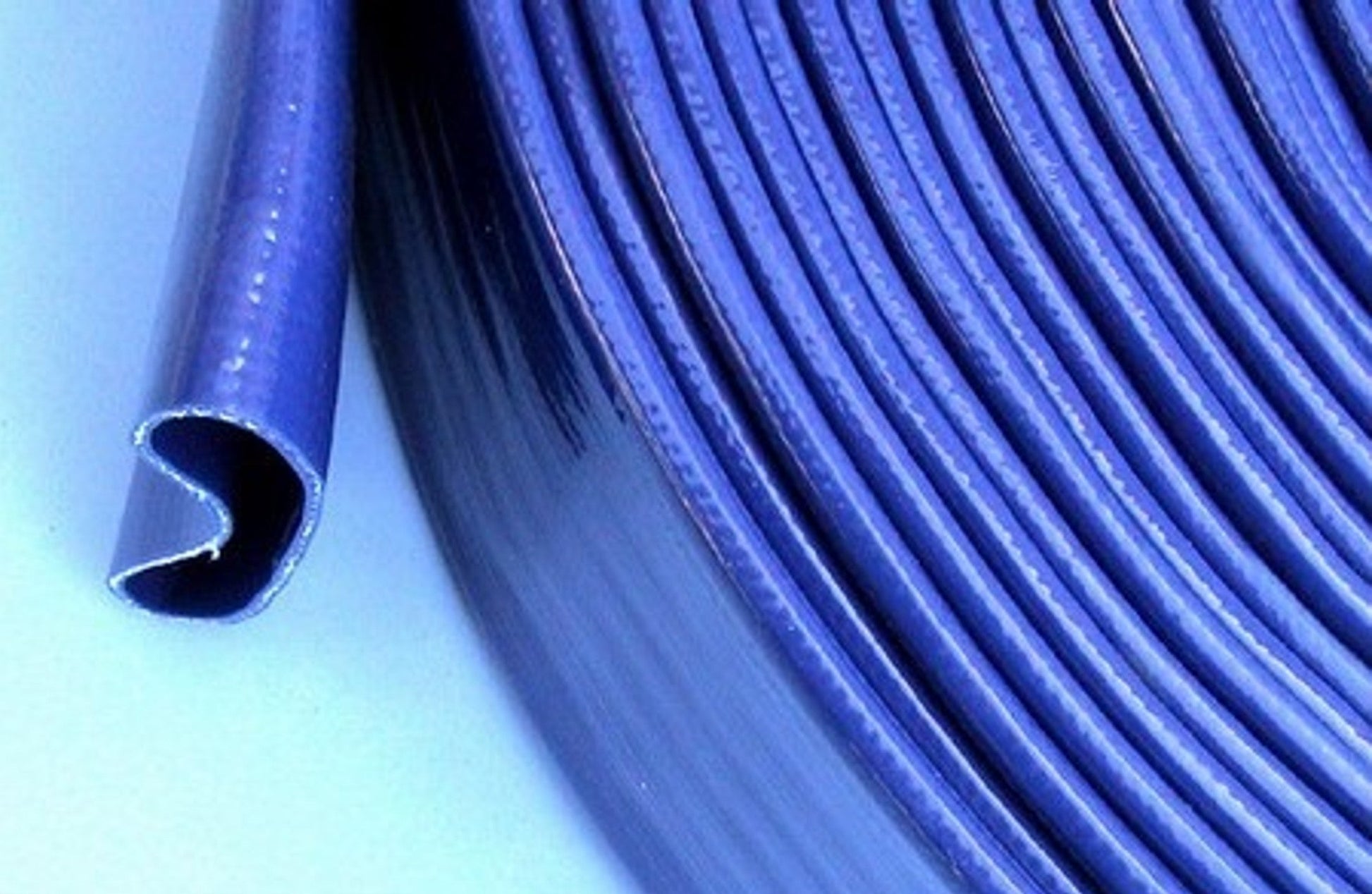 Blue PVC lay flat hose surface detail with parallel ridges and open end