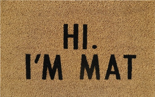 Doormat close-up: 'Hi. I'm Mat' lettering in black on tan coir