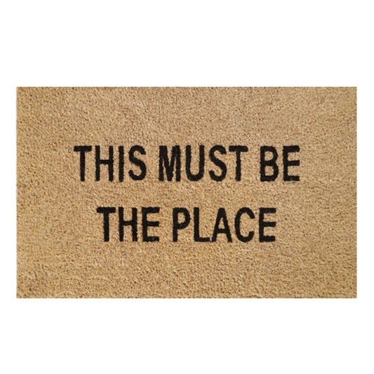 Beige doormat with black text: “THIS MUST BE THE PLACE”