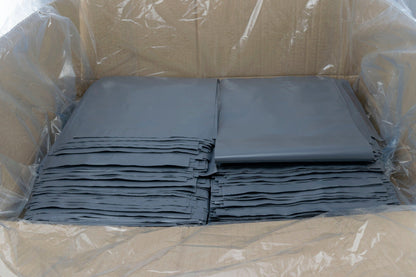 Gray poly mailing bags stacked in clear wrapping with black self-seal edges