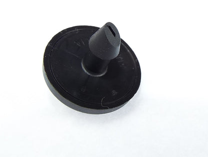 Round black dripper base with central outlet stem, turbulent flow emitter
