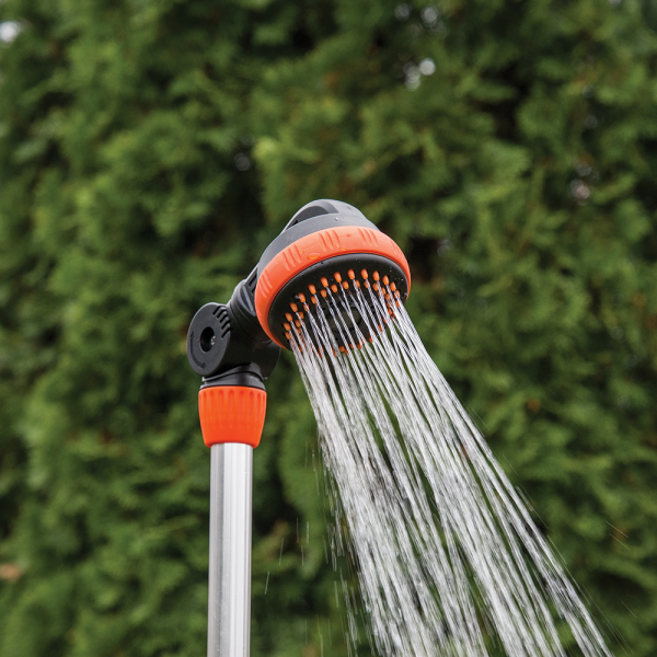 Orange-and-black shower head spraying water from the garden stake