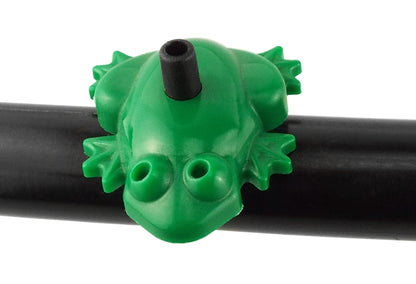Green frog drip emitter clipped onto a black irrigation hose