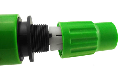 Green hose connector close-up with internal white insert and black threaded coupling