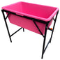 Pink dog bath with drain valve and black metal stand, rectangular tub shape