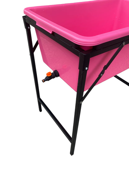 Pink dog bath with black stand and side drain tap