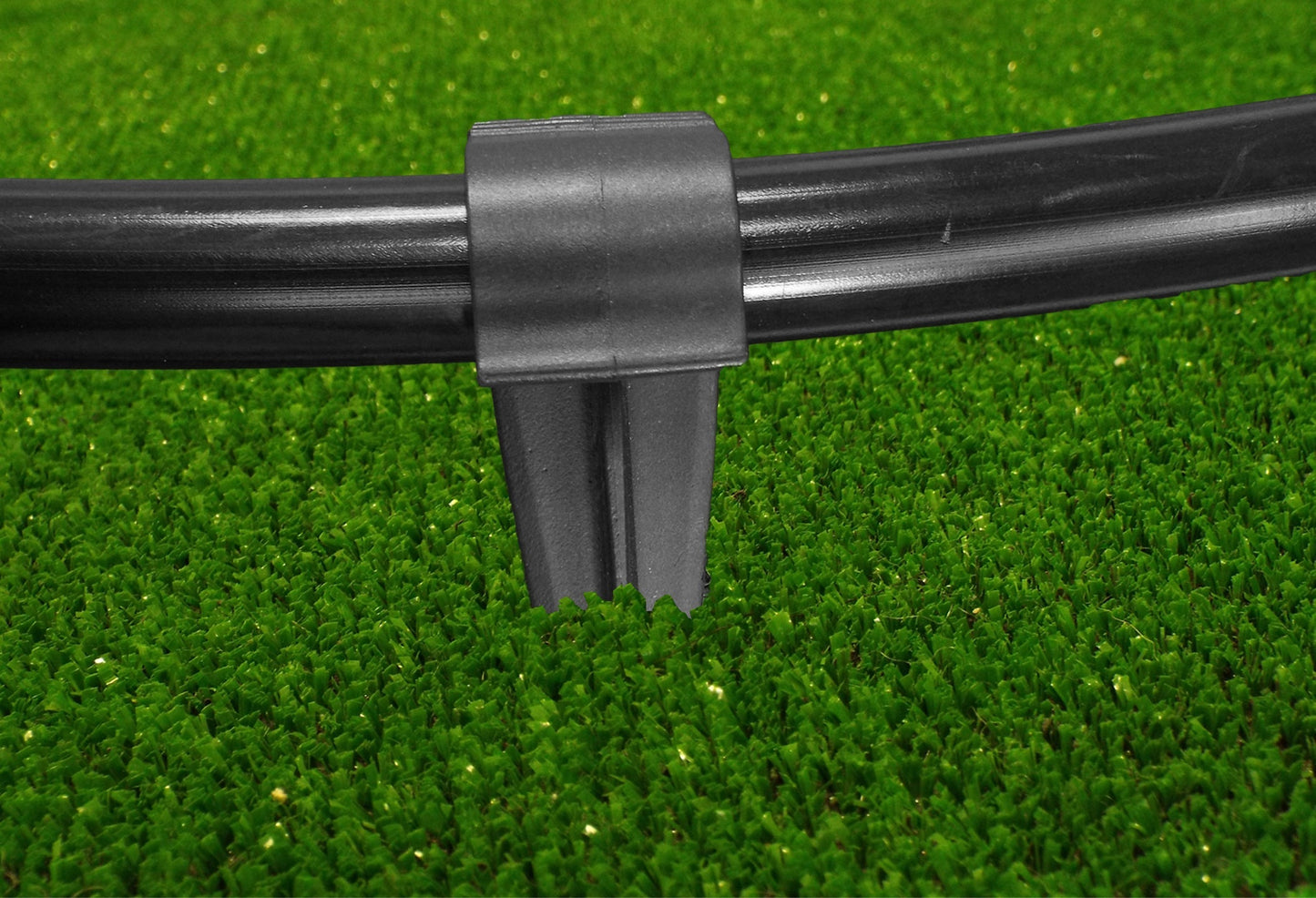 Black clamp and stake base holding a 16mm irrigation pipe securely