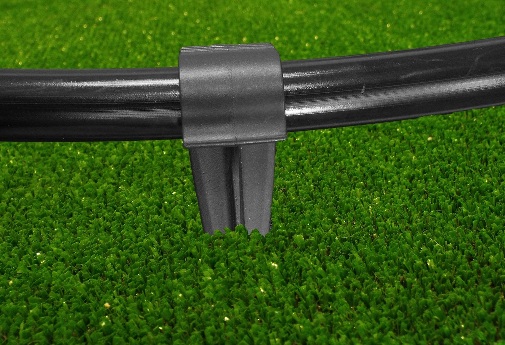 Black clamp and stake base holding a 16mm irrigation pipe securely