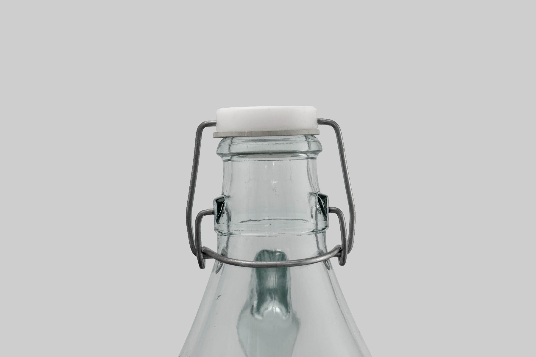 Swing-top cap on glass demijohn with wire latch and white gasket seal