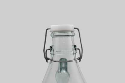 Swing-top cap on glass demijohn with wire latch and white gasket seal