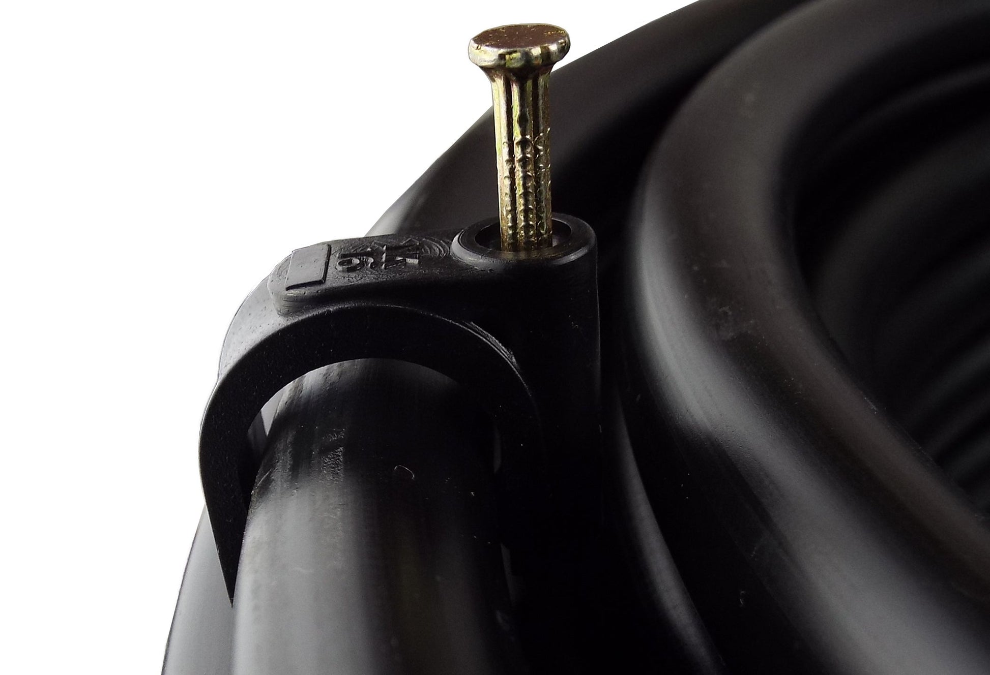 Detail of 16 mm irrigation pipe clip, brass nail on black base