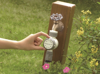 Hand adjusts the time setting on a mechanical water timer attached to a tap