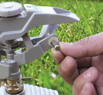 Hand tightening the pulsating lawn sprinkler nozzle on the control arm
